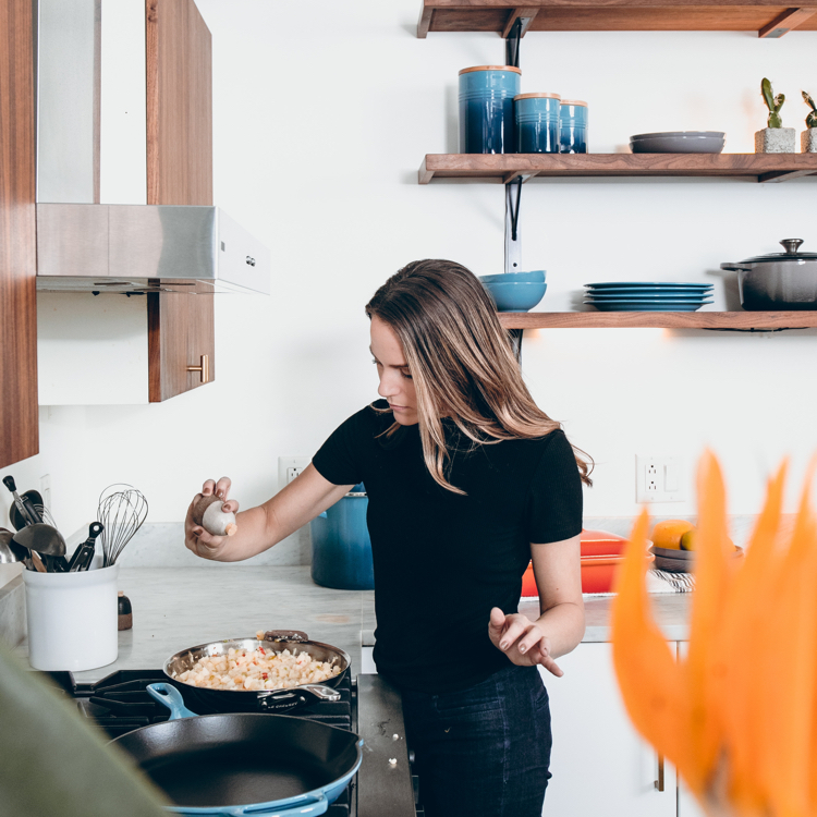 Woman salting fry pan dish